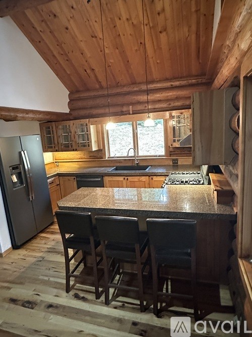 A kitchen with a wooden ceiling and a granite countertop.