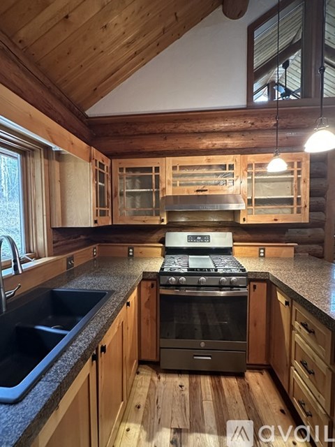 A kitchen with wooden cabinets and a stove top oven.