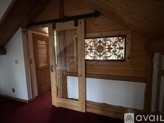 A wooden door with a glass window in the middle is open.