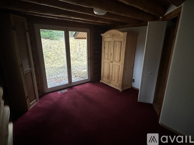 A room with a wooden floor and a wooden cabinet with a sign on it.