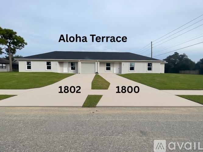 A white building with the words Aloha Terrace written on it.