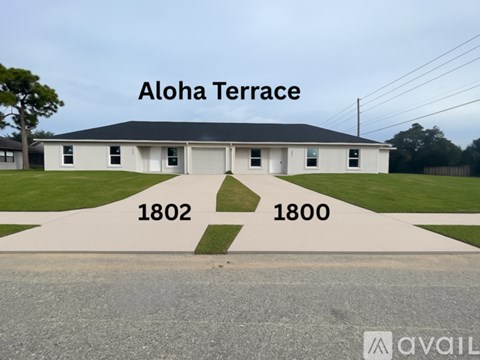 A white building with the words Aloha Terrace written on it.
