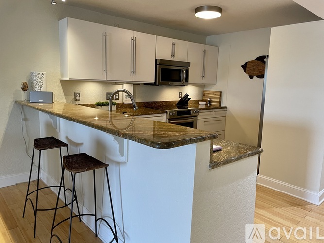 A kitchen with a bar area and stools.