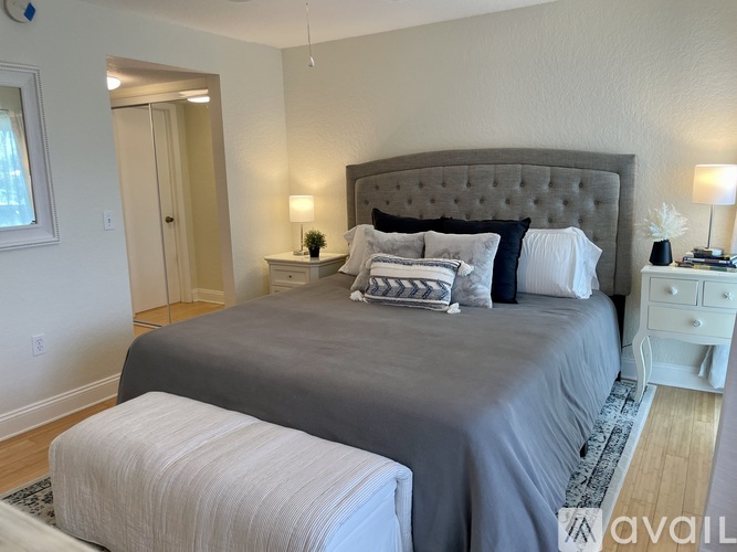 A bedroom with a large bed and a white nightstand.
