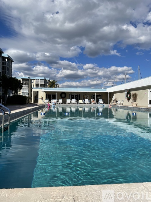 A large swimming pool with people in it and a cloudy sky.