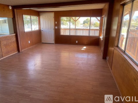A room with wooden flooring and a balcony with a railing.