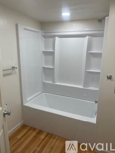 A white walk-in closet with shelves and a door.