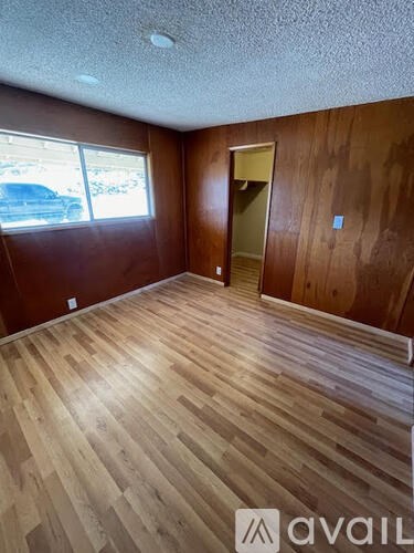 A room with wooden flooring and a door.
