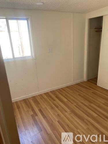 A room with wooden flooring and a window.