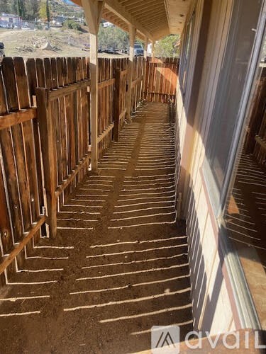 A wooden fence is being constructed on a sunny day.