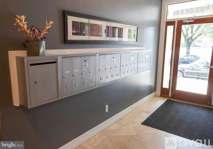 A grey cabinet with a vase of flowers on top of it.