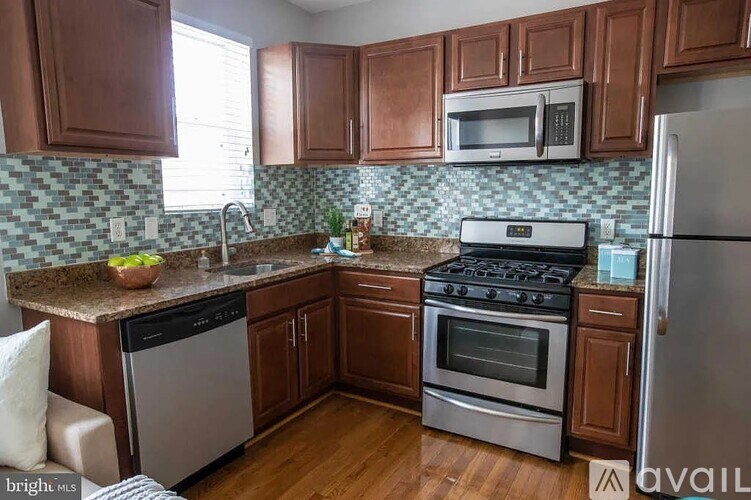 A kitchen with wooden cabinets and a tile backsplash.