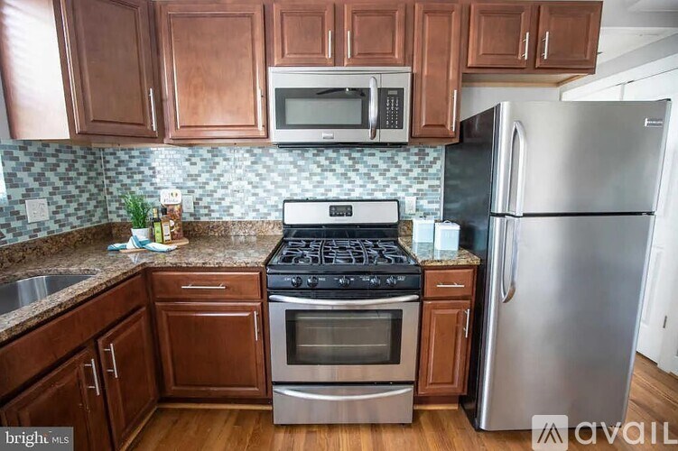 A kitchen with a stove top oven and a refrigerator.