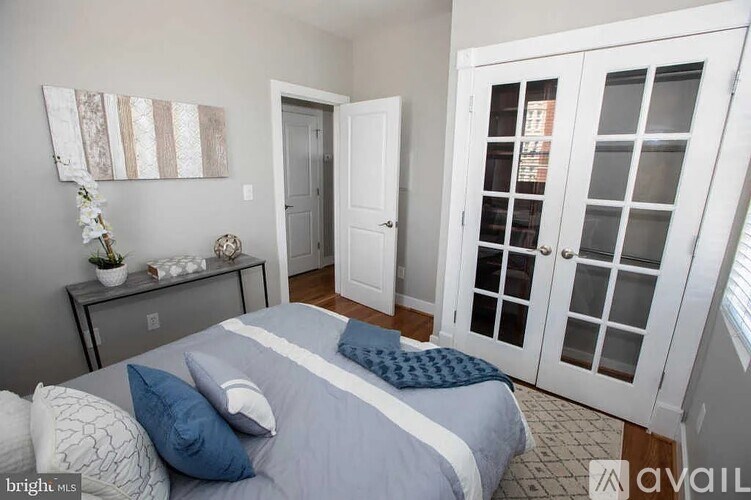 A bedroom with a bed, nightstand, and a wall hanging.