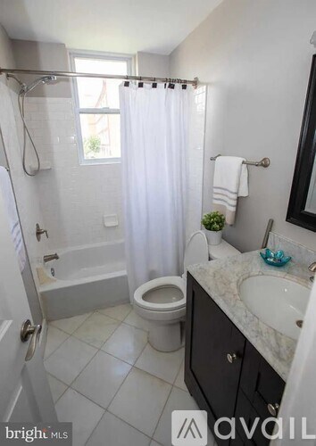 A bathroom with a toilet, sink, and shower.