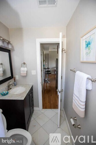 A bathroom with a toilet, sink, and mirror.