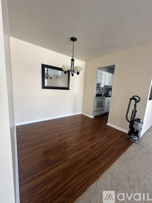 A room with wooden flooring and a vacuum cleaner.
