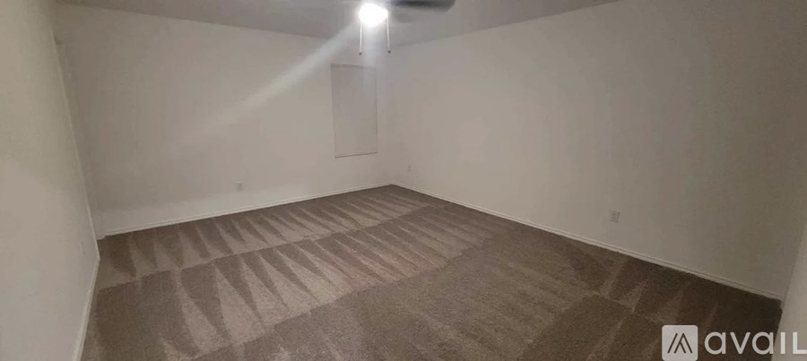 A room with a carpeted floor and a white wall.