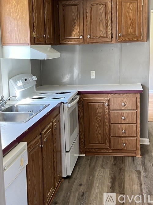 A kitchen with wooden cabinets and a white oven.