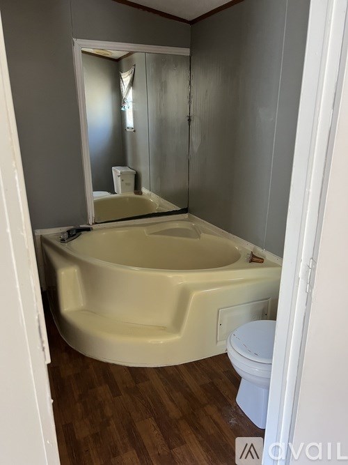 A white toilet sits next to a bathtub in a bathroom.