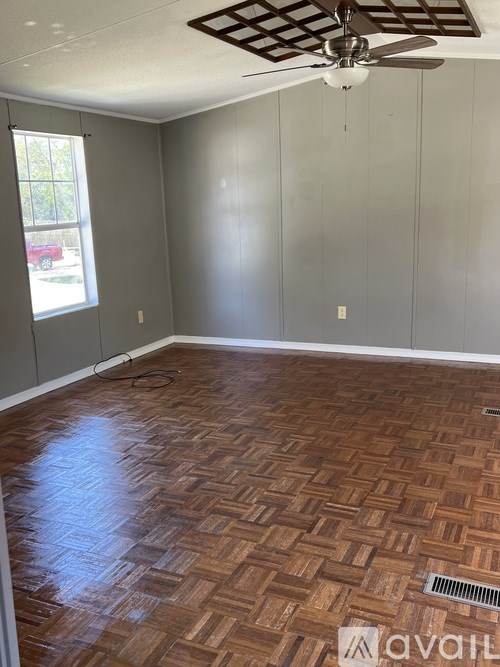 A room with a wooden floor and a ceiling fan.