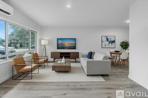 A living room with a large couch, a coffee table, and a painting on the wall.
