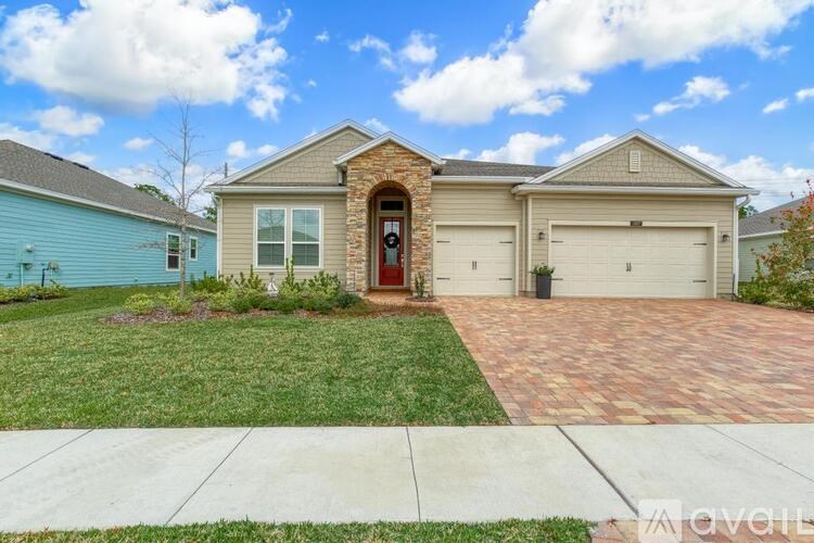 A house with a red door and a brick driveway.