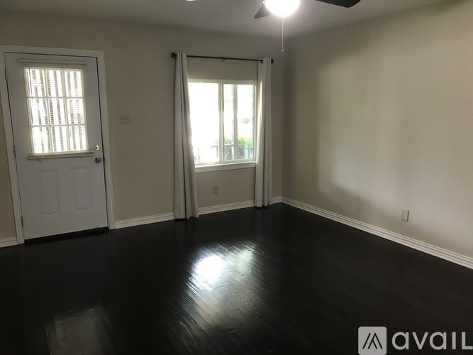A room with a white door and a window with white curtains.