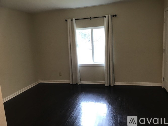 A room with a sliding door and black flooring.