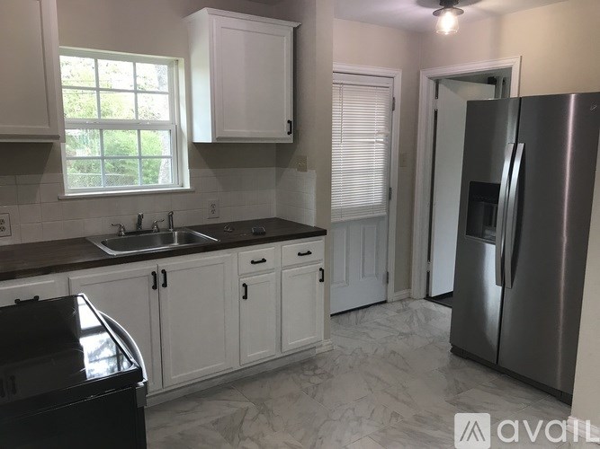 A kitchen with a sink, stove, and refrigerator.