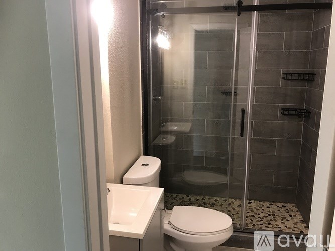 A white toilet sits next to a white sink in a tiled bathroom.