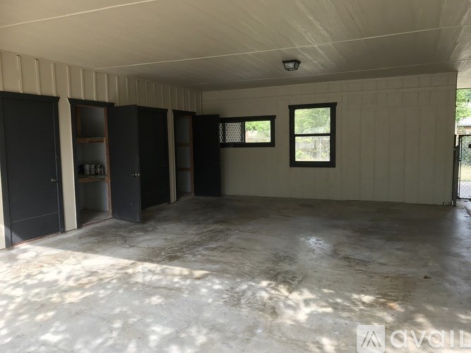 A large empty room with a window and a door.