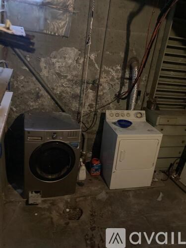 A dirty basement with a washing machine and a dryer.