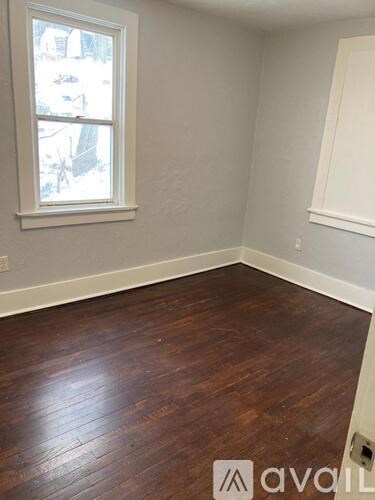 A room with a window and wooden flooring.