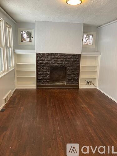 A room with a fireplace and wooden floors.