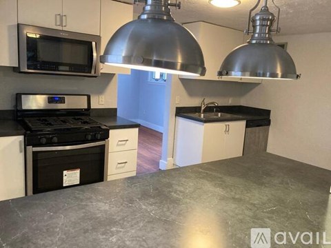 A kitchen with a black stove top oven and a black microwave.