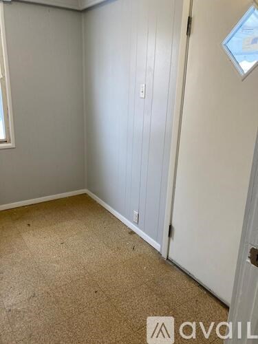 A room with a carpeted floor and a door.
