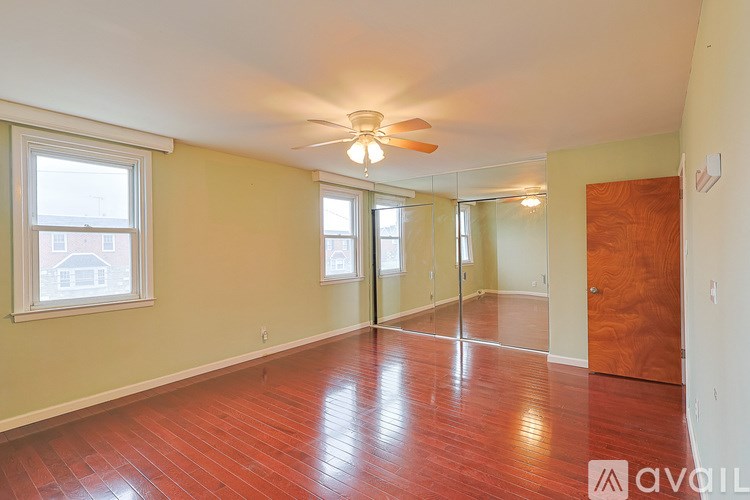 A room with a ceiling fan and wooden floors.