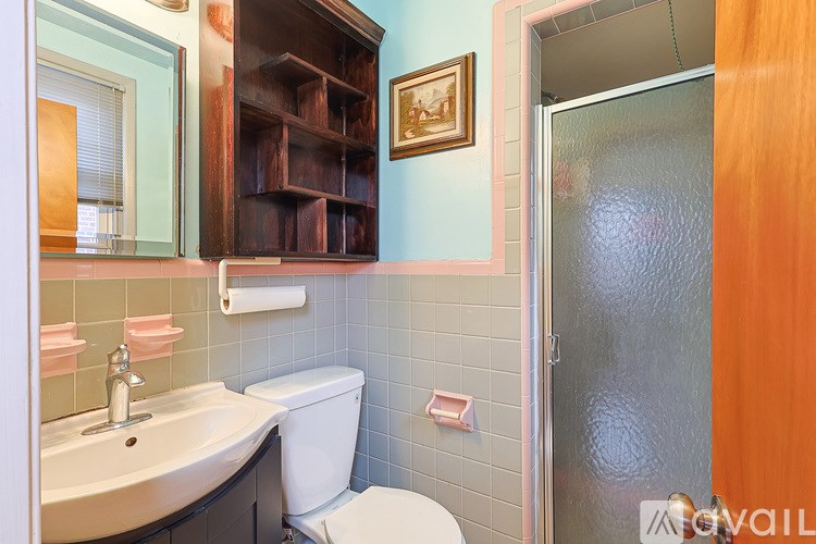 A bathroom with a toilet, sink, and a shower door.