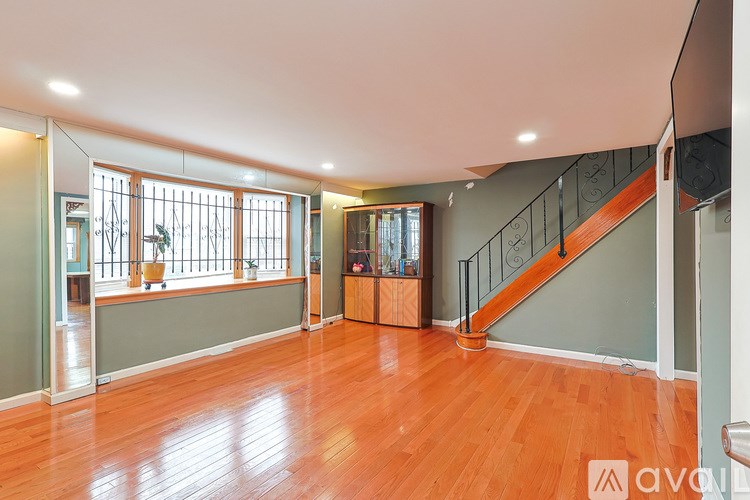 A room with wooden floors and a staircase.
