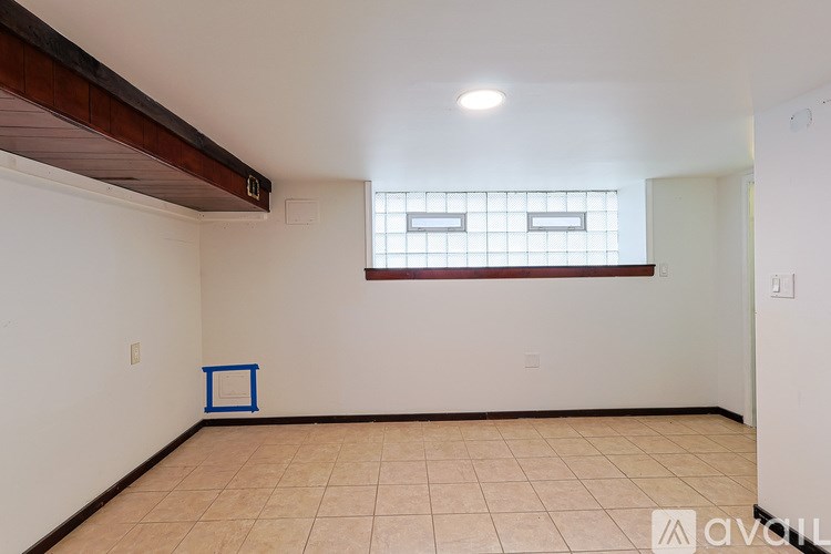 A room with a window and a blue square on the floor.
