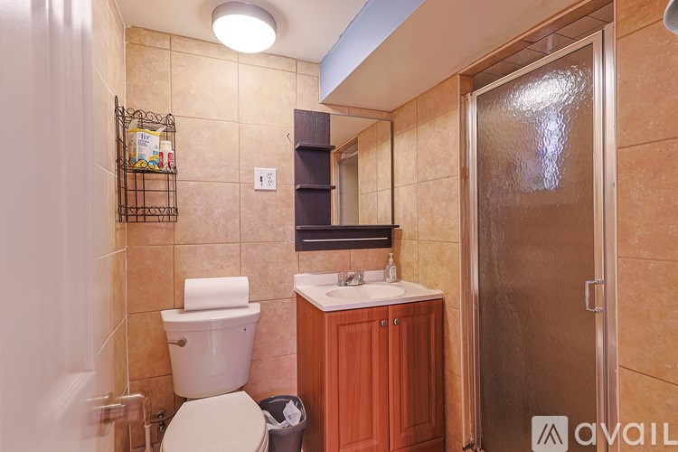 A bathroom with a toilet, sink, and mirror.