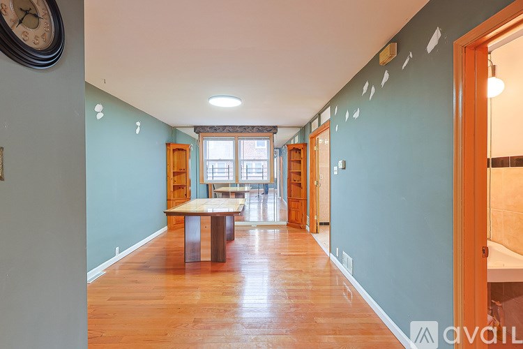 A long hallway with a table and chairs in the middle.