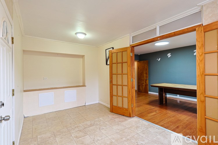 A room with a wooden door and a bench.