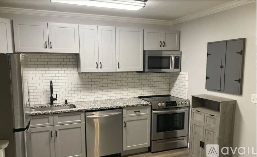 A kitchen with white cabinets and stainless steel appliances.
