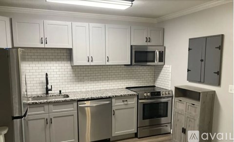 A kitchen with white cabinets and stainless steel appliances.