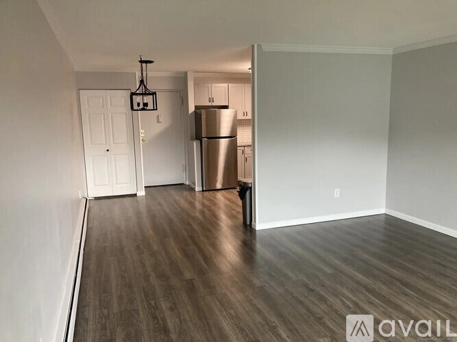 A kitchen area with a refrigerator and a door leading to another room.
