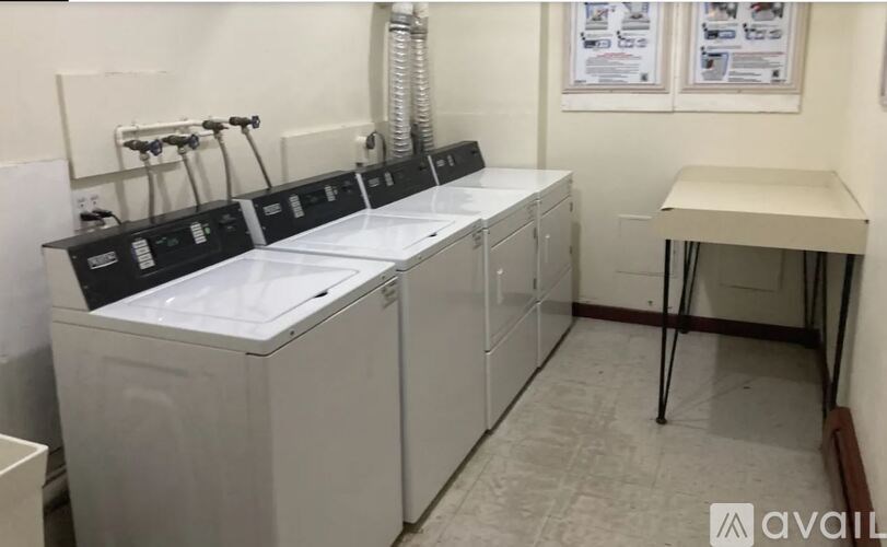 A row of washing machines are lined up in a laundromat.
