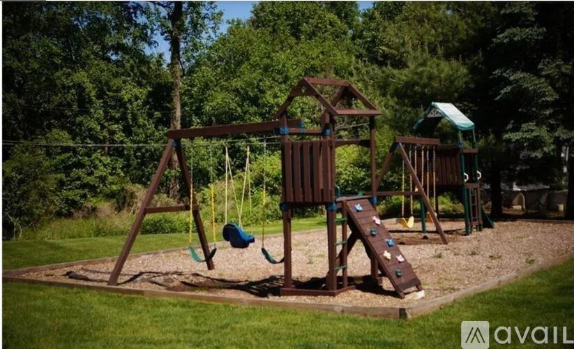 A wooden swing set with a blue slide in a playground.
