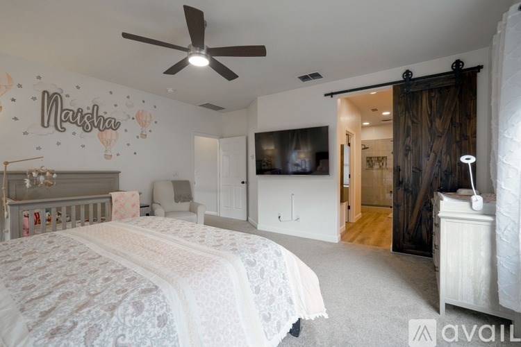 A bedroom with a white bed and a ceiling fan.